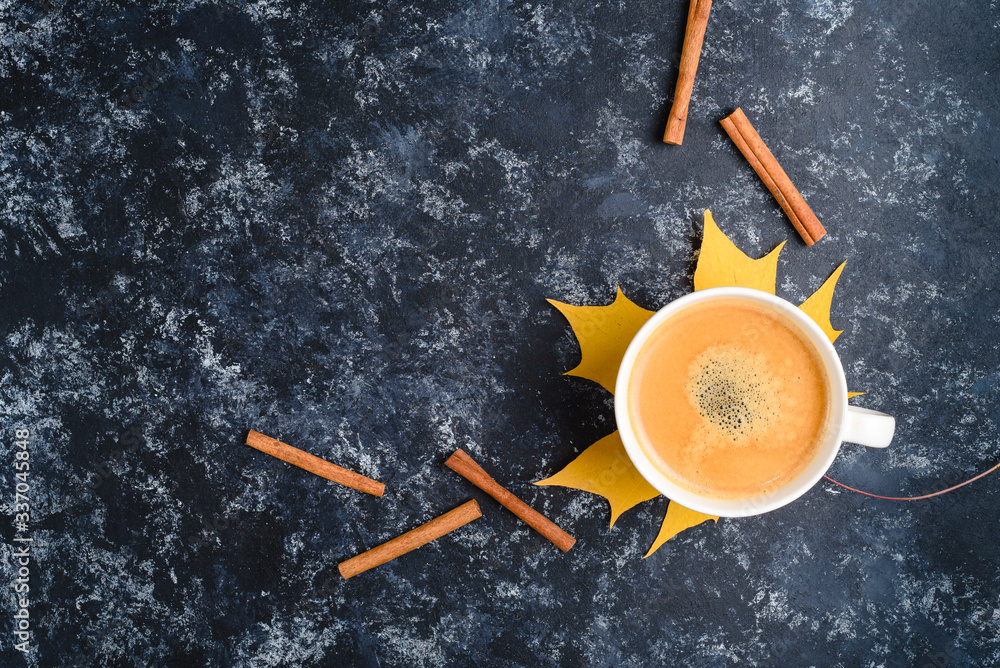 Autumn coffee composition, coffee cup with foam, cinnamon, autumn leaf at black background. Fall hot drinks, cafe and bar concept Autumn coffee composition, coffee cup with foam, cinnamon, autumn leaf at black background. Fall hot drinks, cafe and bar concept
