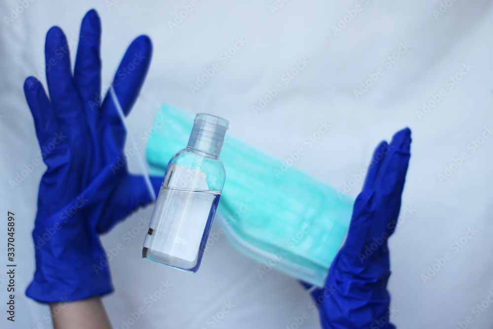 Catching bottle of sanitizer durring deficit. Washing hands with sanitizer, wearing medical mask and gloves Catching bottle of sanitizer durring deficit. Washing hands with sanitizer, wearing medical mask and gloves