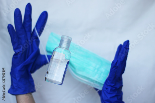 Catching bottle of sanitizer durring deficit. Washing hands with sanitizer, wearing medical mask and gloves