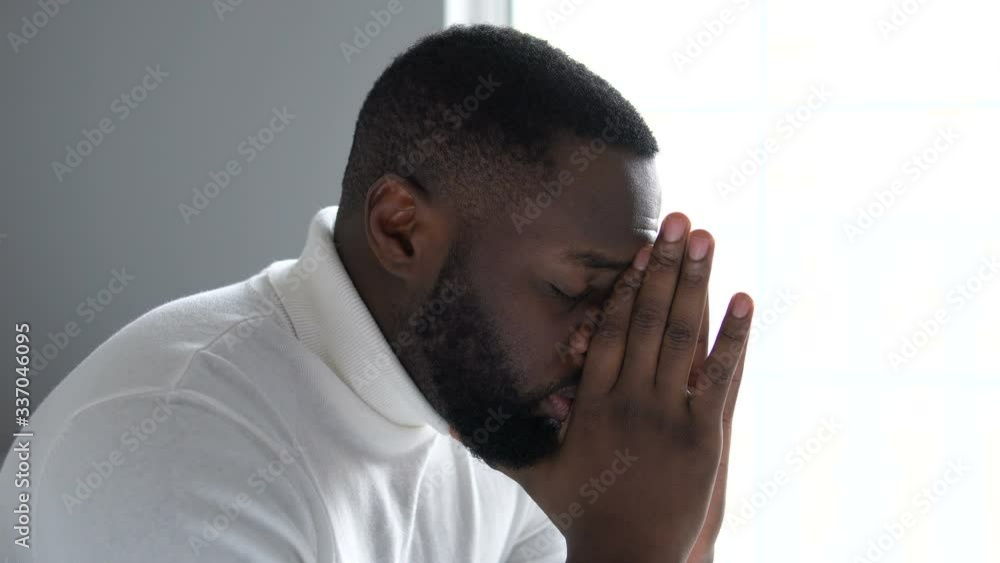 Nervous african american man going through difficult period in life, praying Nervous african american man going through difficult period in life, praying