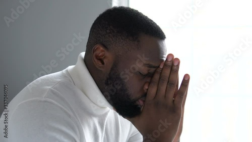 Nervous african american man going through difficult period in life, praying