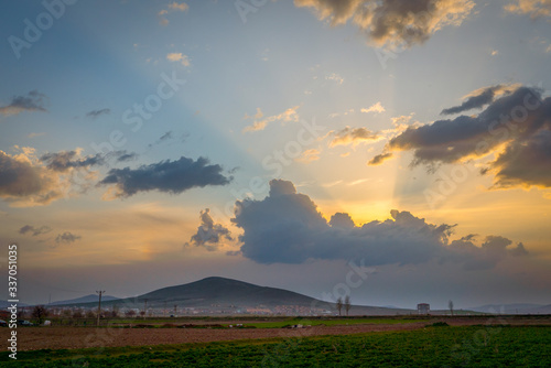 Dramatic black and red clouds with sunbeam over adacal hill at sunset, Emirdag, Afyonkarahisar, Turkey