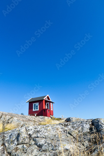 Beautiful red cottage in the Swedish Archipelago. Blue Sky.