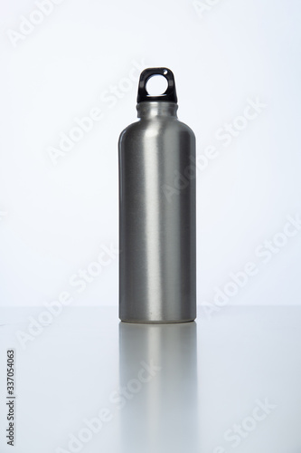 Aluminum bottle water placed on a wooden table in a restaurant or shop, Concept: Reduce plastic waste to recycle reusable and ecology nature, stainless glossy metal-containing liquid for sport.