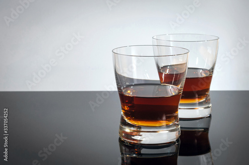 Two glasses of whiskey on a black table