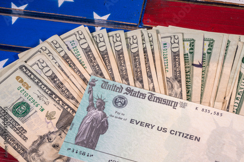 Obraz na plátne Stack of 20 dollar bills with illustrative coronavirus stimulus payment check on