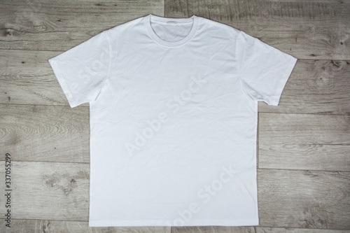 Close up of white t-shirt on the wooden table. Blank t-shirt for add your design