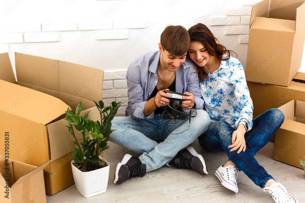 Smiling couple leaning on boxes in new home Smiling couple leaning on boxes in new home