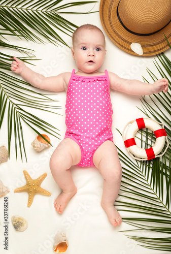 Cute baby girl with beach accessories. Holidays at sea with baby, summer concept