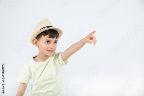 boy in hat points to the side on white background