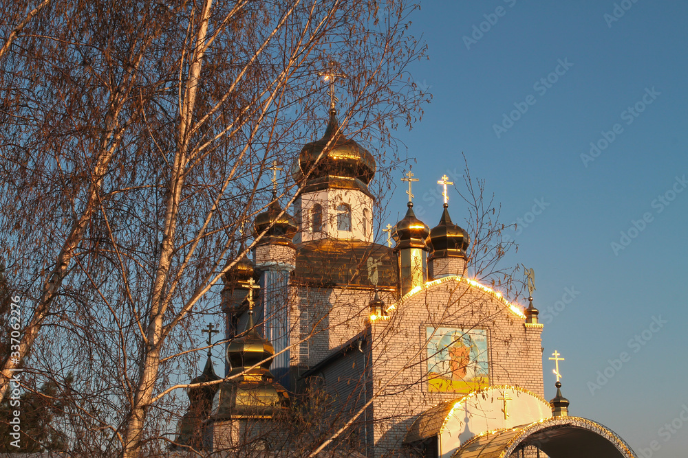 Church behind the birches against the blue sky Church behind the birches against the blue sky