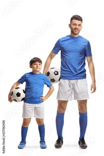 Young man and a boy footballers holding soccer balls