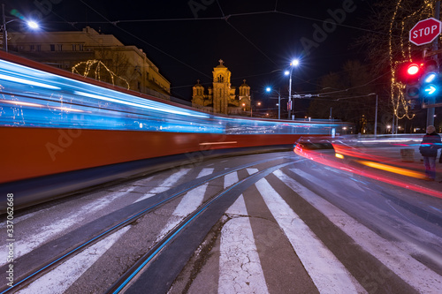 Long exposure of Saint Mark's church at night and light trails from passing trams and buses