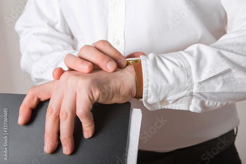 Close up of businessman looking at watch on his hand free space. Man in white shirt checking time from luxury wristwatches. Groom wedding preparation.