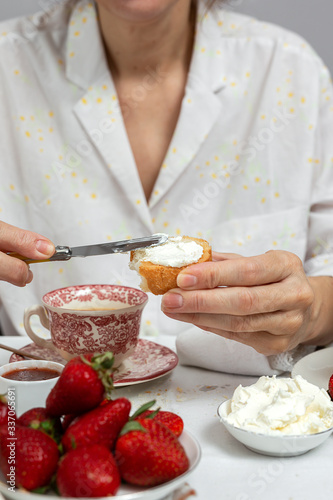 Unrecognizable woman having breakfast in pajamas at home in quarantine