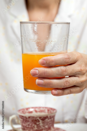 Unrecognizable woman having breakfast in pajamas at home in quarantine