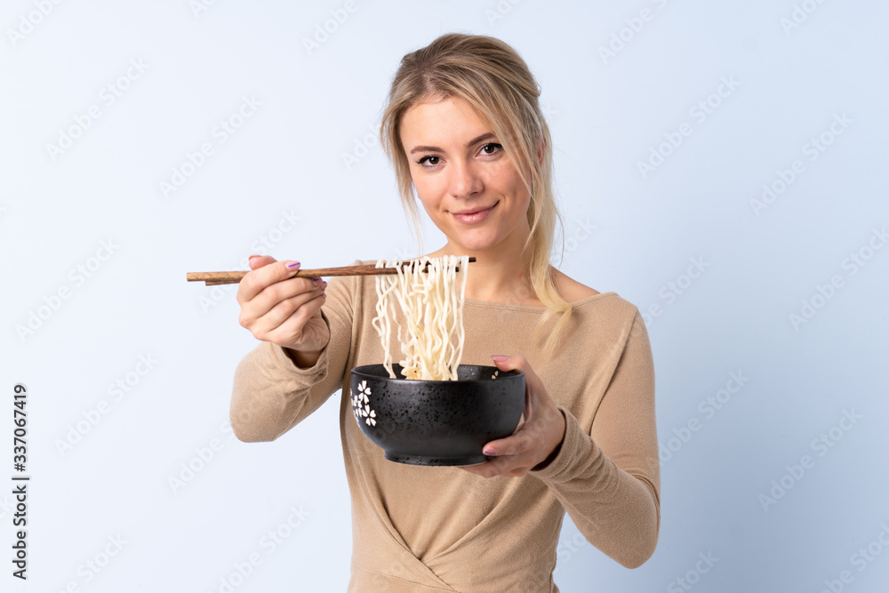 Blonde woman over isolated blue background holding a bowl of noodles with chopsticks and offering it Blonde woman over isolated blue background holding a bowl of noodles with chopsticks and offering it