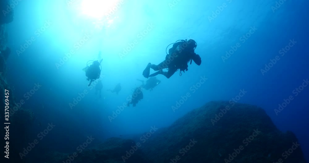 scuba divers are exploring underwater wit sun beams and sun rays ocean scenery scuba divers are exploring underwater wit sun beams and sun rays ocean scenery