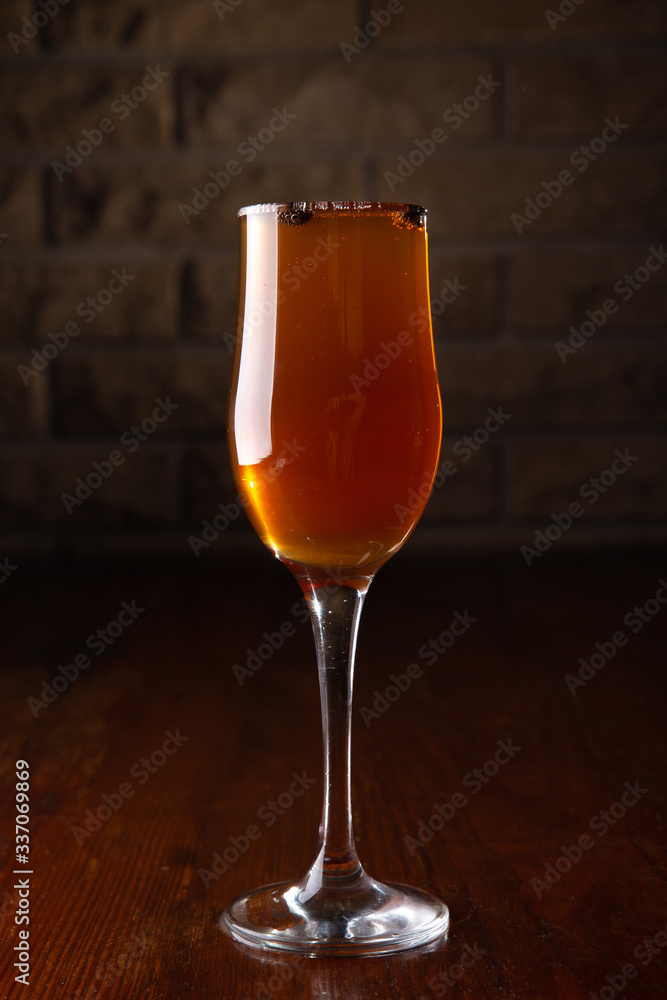 Glass of alcoholic drink with coffee grains on a wooden old table Glass of alcoholic drink with coffee grains on a wooden old table