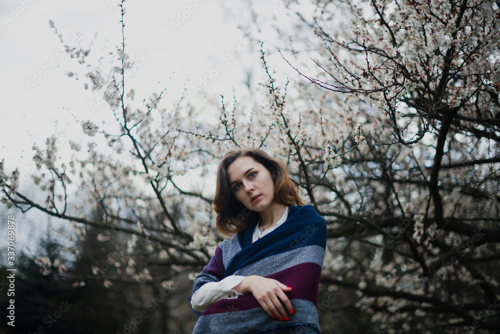 Beautiful young girl is resting and enjoying spring in the spring park Beautiful young girl is resting and enjoying spring in the spring park