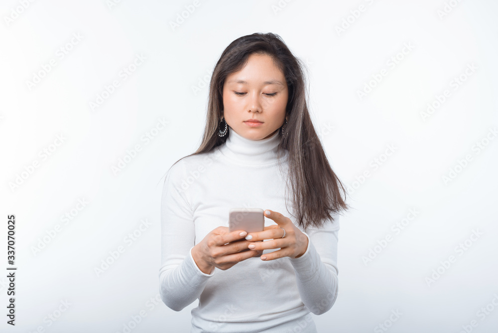 Photo of young woman standing over white background and writing a message Photo of young woman standing over white background and writing a message