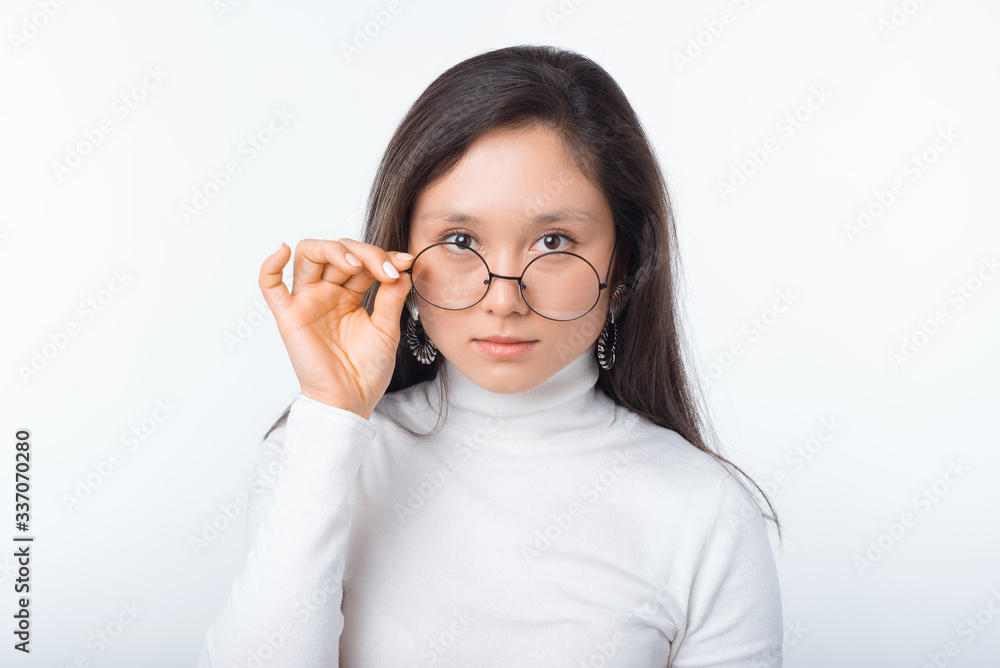 Close up portrait of beautiful young woman wearing round glasses and looking confident at the camera Close up portrait of beautiful young woman wearing round glasses and looking confident at the camera