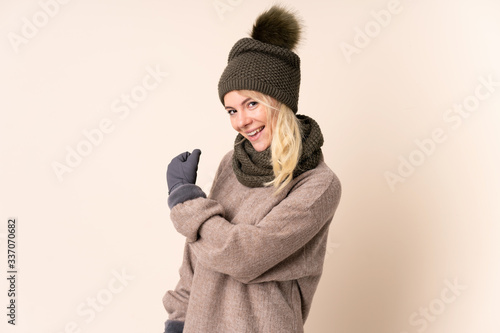 Young woman with winter hat over isolated background celebrating a victory © luismolinero