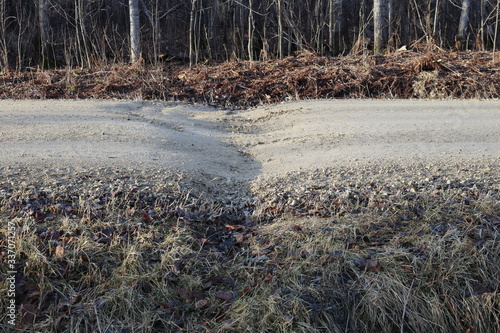 Gravel road, frost heave and dip at center line culvert
