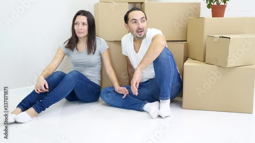 Young wife and husband carried heavy big boxes into new flat and then resting together tired but satidfied. photo