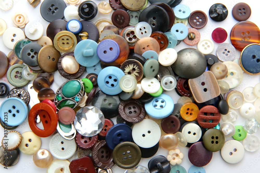 Different colors and shapes of plastic buttons scattered on the table. Different colors and shapes of plastic buttons scattered on the table.