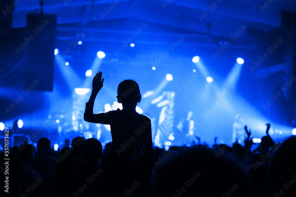 silhouette of a girl in a concert crowd in front of the stage. fanaticism from a music group. banner for a concert festival
