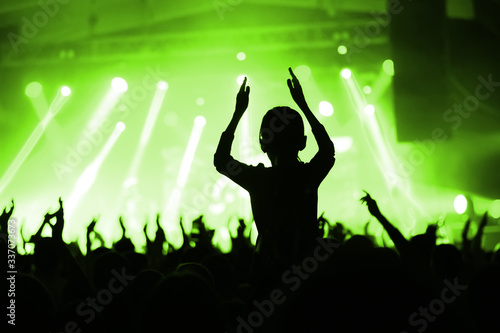 silhouette of an applauding crowd in front of the stage. banner for a music festival. poster of the upcoming show.
