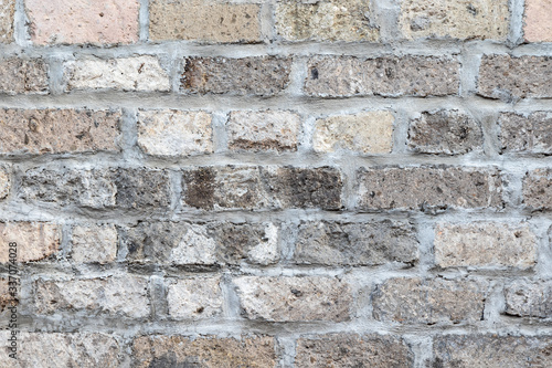 Closeup of brick wall, gray and brown rough bricks. Mortared joints. Indonesian alleyway, Denpasar, Bali, Indonesia. 