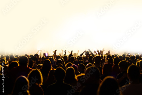 crowd with raised hands at a concert of a music festival. Silhouettes of people in front of a stage with an artist. night disco