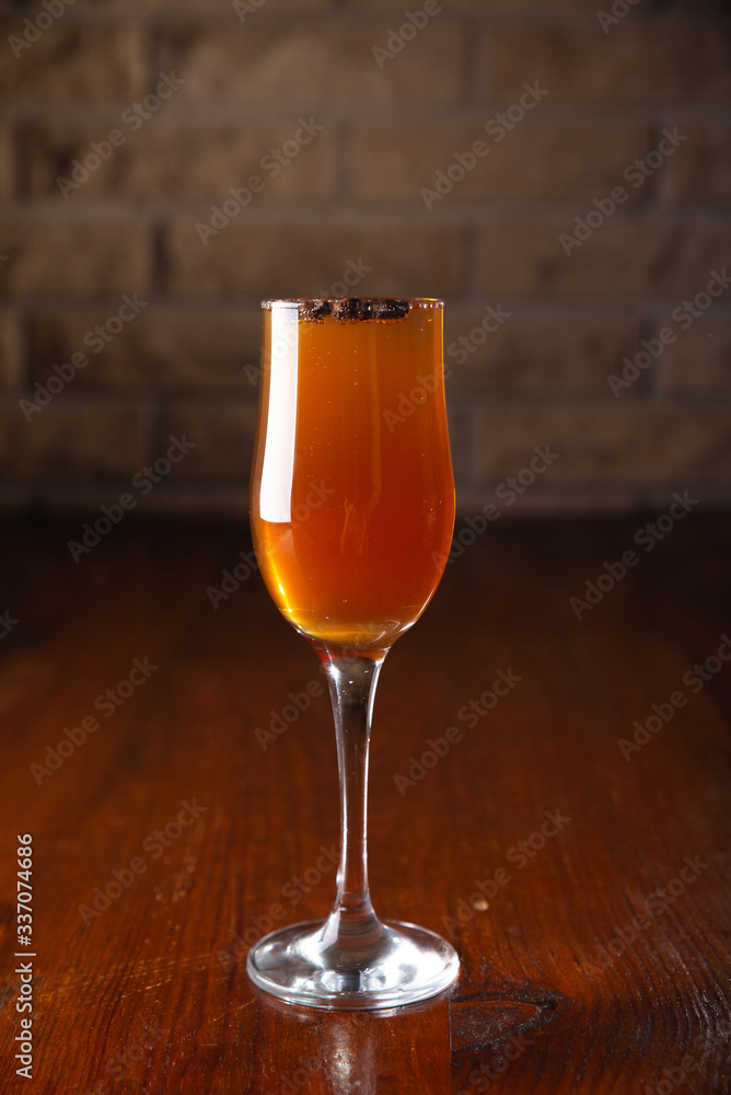 Glass of alcoholic drink with coffee grains on a wooden old table Glass of alcoholic drink with coffee grains on a wooden old table