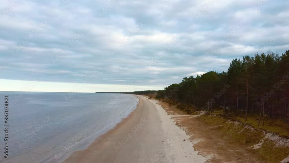 Aerial Dron Shot Klapkalnciems Beach, Latvia Baltic Sea Suny Winter Day Big Clouds Sand Dunes With Pine Trees Aerial Dron Shot Klapkalnciems Beach, Latvia Baltic Sea Suny Winter Day Big Clouds Sand Dunes With Pine Trees