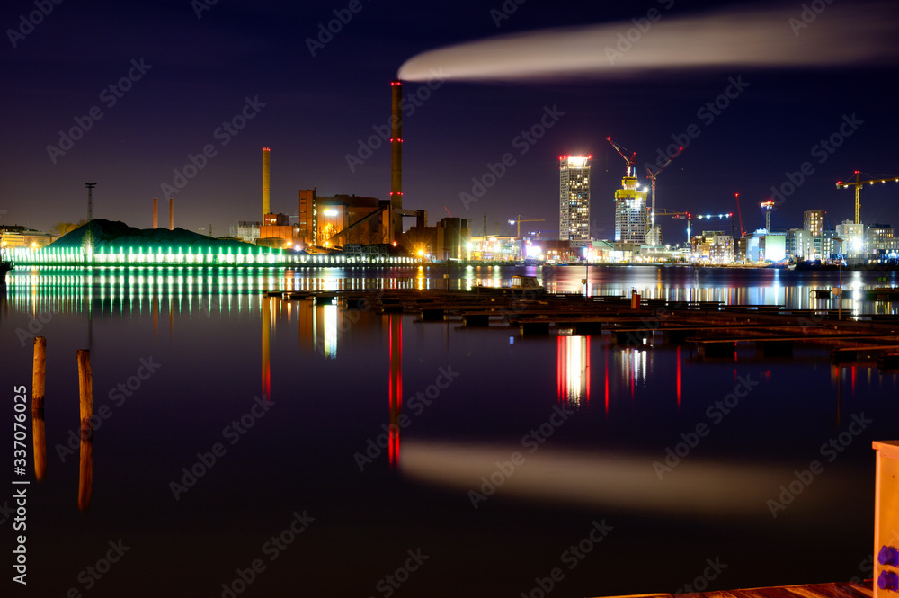 Night cityscape of evolving residential area and old industrial building.