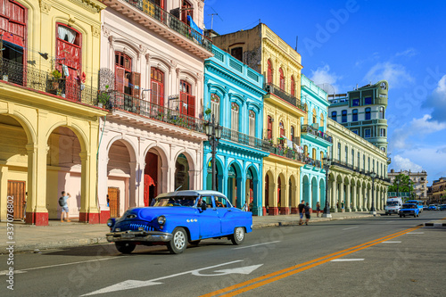 Havana Cuba A blue oldtimer car driving Habana Vieja in a colorful facade street. © Brice