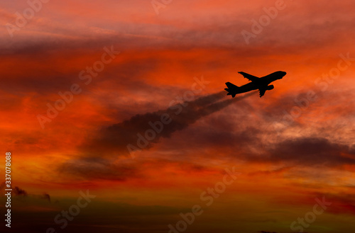 Airplane taking off at sunset. Silhouette of a big passenger or cargo aircraft, airline. Transportation.