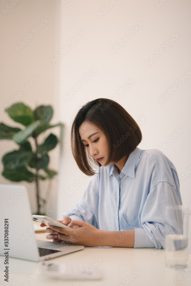 Attractive young businesswoman sitting alone at a desk Attractive young businesswoman sitting alone at a desk