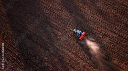 aerial view of tractor , combine cultivating field. drone shot. picture with space for text. Farmland from above