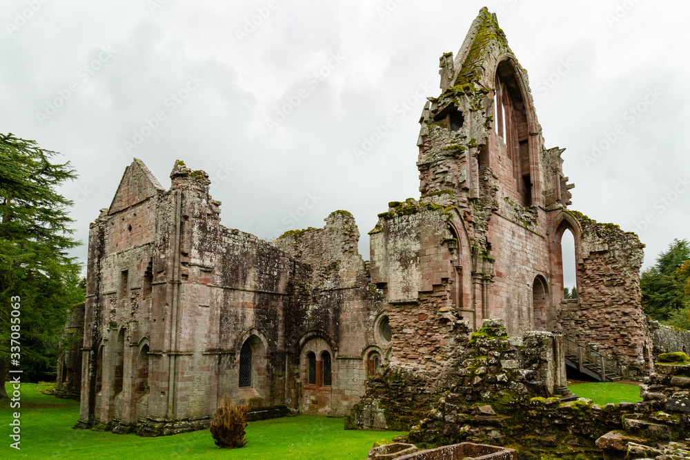 Moody soft light falls on Dryburgh Abbey ruins in the Borders area of Scotland, United Kingdom