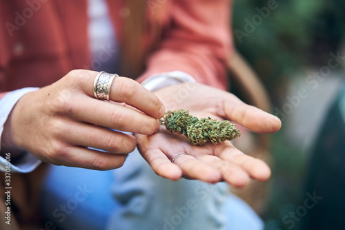 womans hands holding cannabis flower