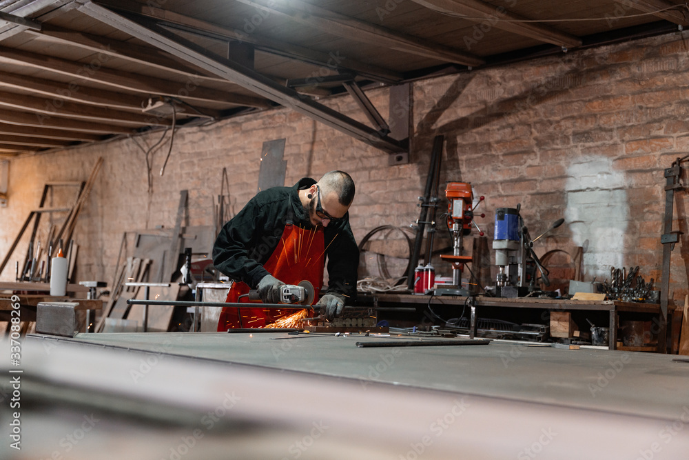 Metal worker in glasses cutting details Metal worker in glasses cutting details