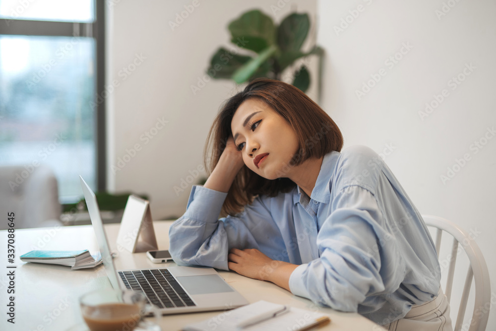 Bored millennial female worker lie at office desk look at laptop screen think about problem solution Bored millennial female worker lie at office desk look at laptop screen think about problem solution