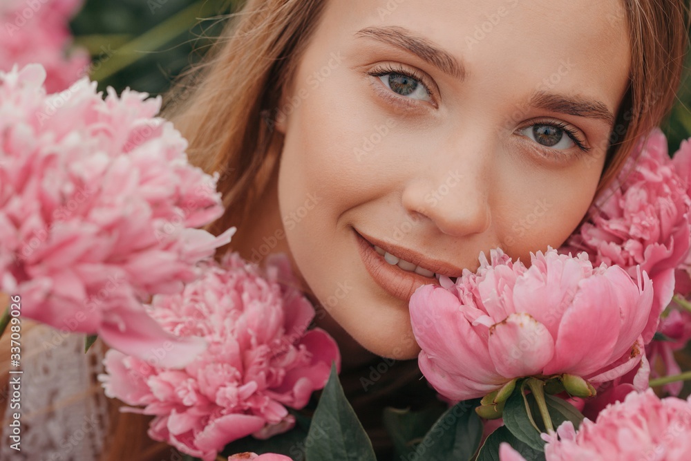Beauty portrait of young blond woman with pink peonies Beauty portrait of young blond woman with pink peonies