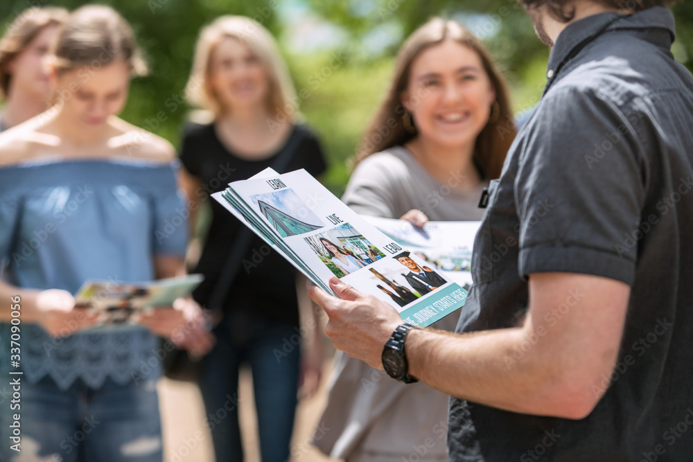 Tour: Guide Holds Stack Of Information Folders To Hand Out Tour: Guide Holds Stack Of Information Folders To Hand Out