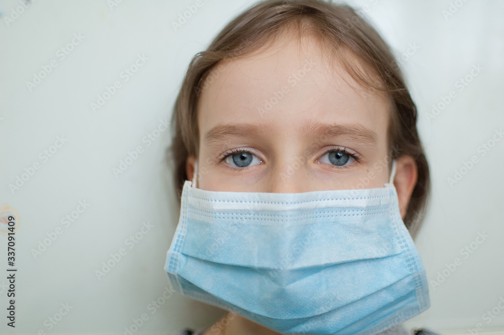 Coronavirus Covid-19 outbreak. Little blonde girl with blue eyes wearing disposable mask for protection of virus on white background in studio. Quarantine concept Coronavirus Covid-19 outbreak. Little blonde girl with blue eyes wearing disposable mask for protection of virus on white background in studio. Quarantine concept