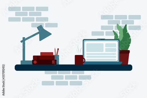 Work table with notebook, desk lamp, books, cup and plant. 