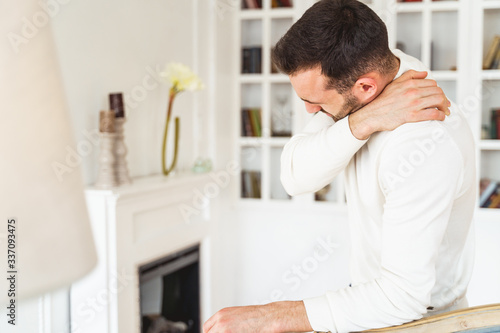 Male touching his neck with his hand